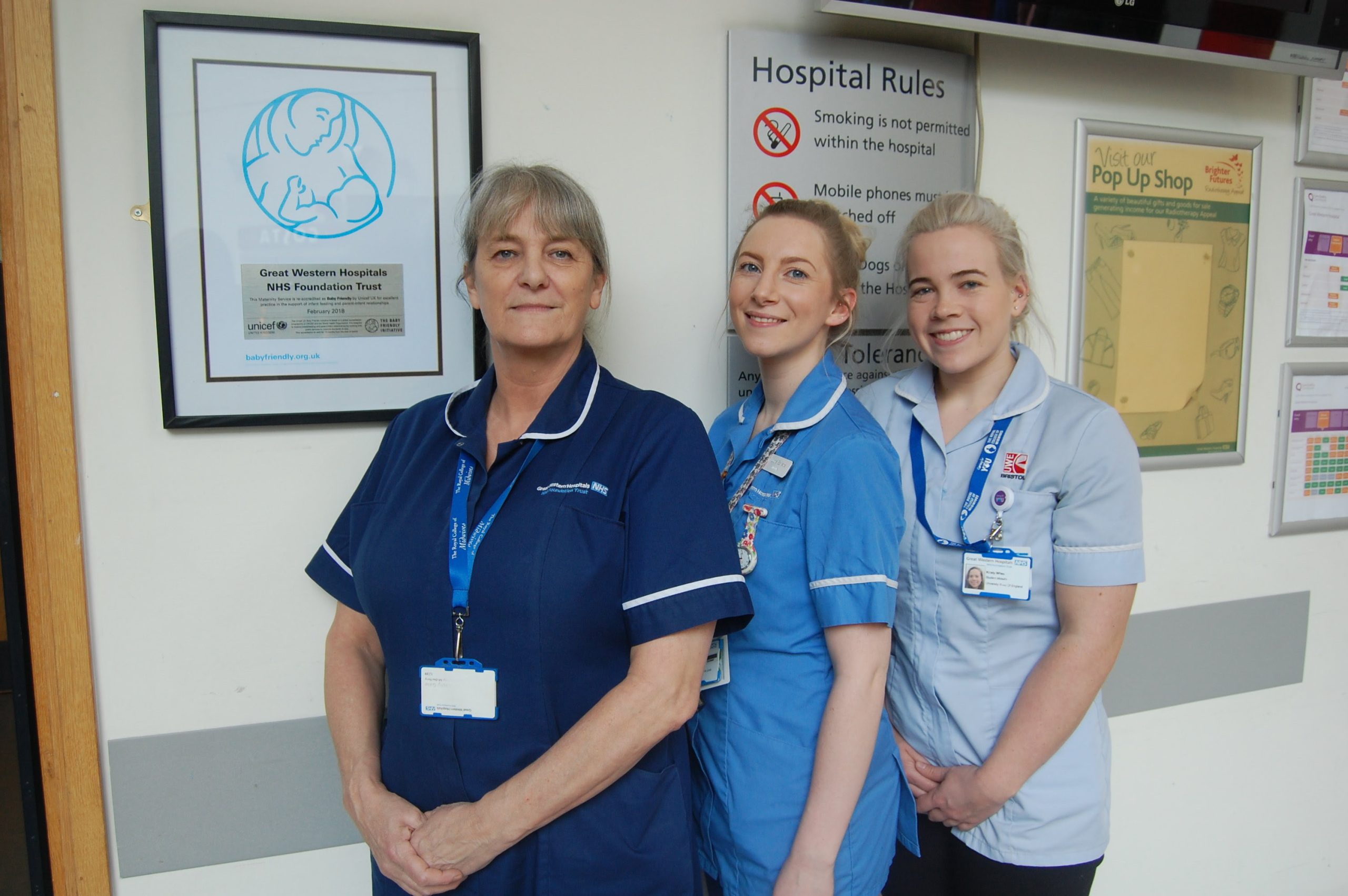 Cathy Gale, Lucia Szweda, Midwife, and Kirsty Wheeler, Student Midwife, in front of the new plaque in GWH's Atrium reception.