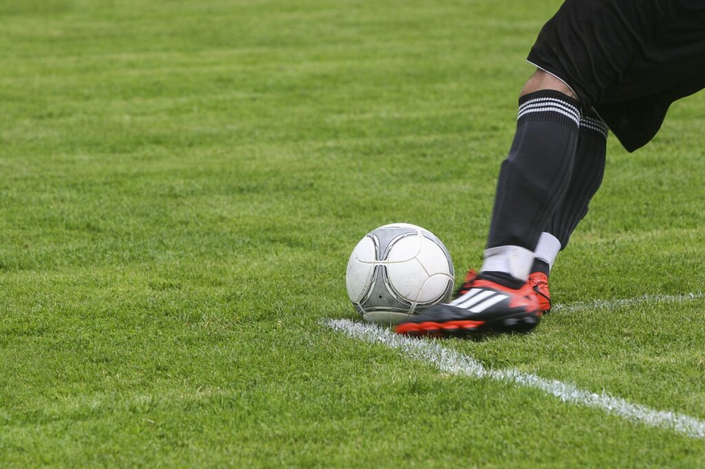 man kicking a football